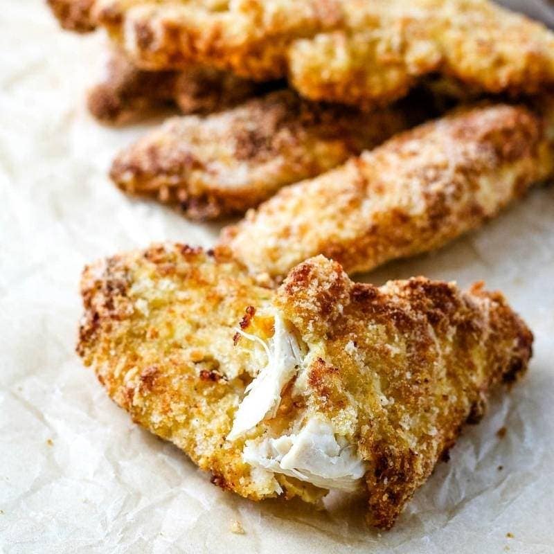 close up of cooked chicken tenders on parchment paper