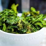 close up of air fried kale chips in a white bowl after cooking